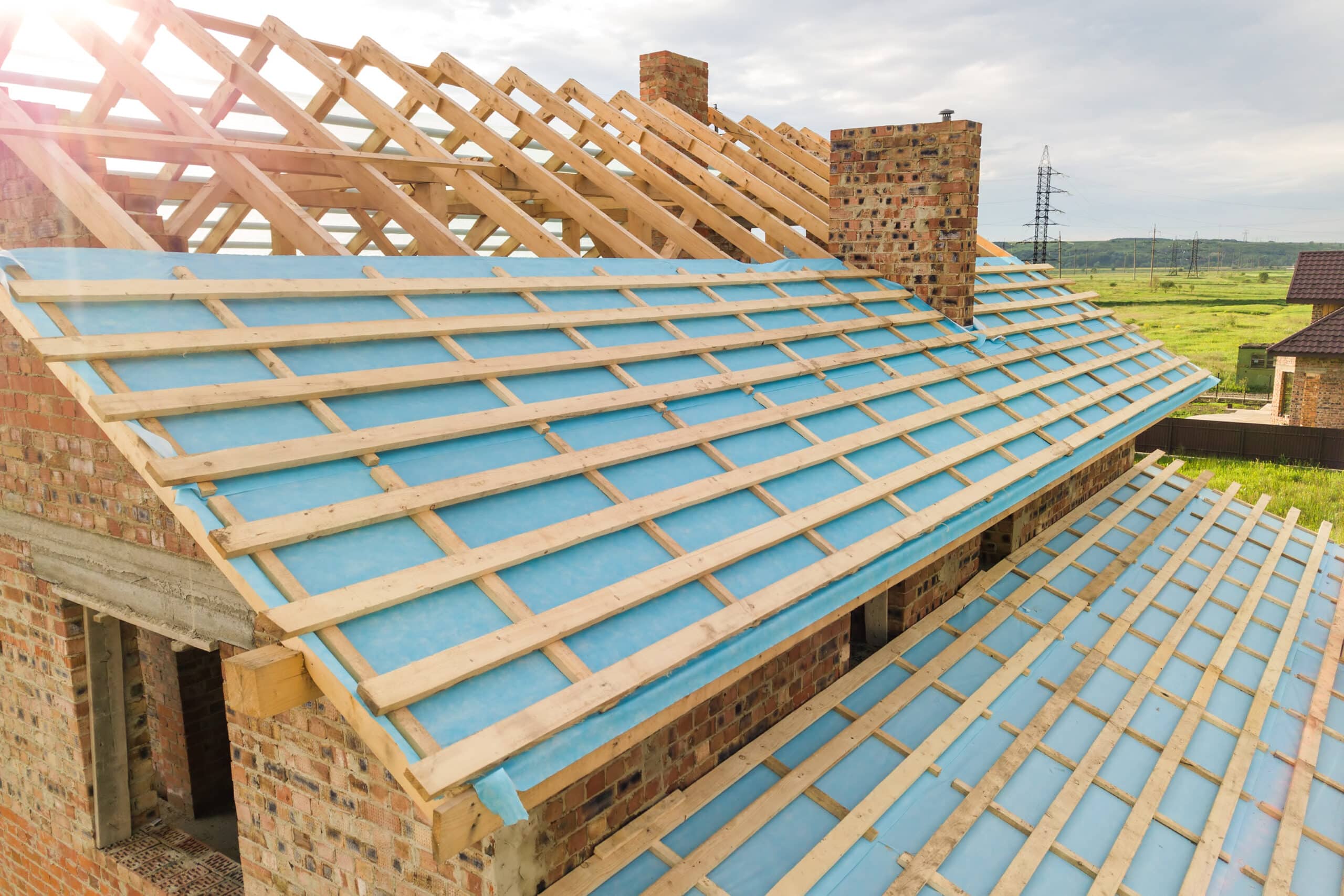 Aerial view of a brick house with wooden roof frame under construction brick house