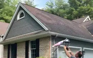 Homeowner comparing different gutter guard systems to choose the best option for protecting their home’s gutters