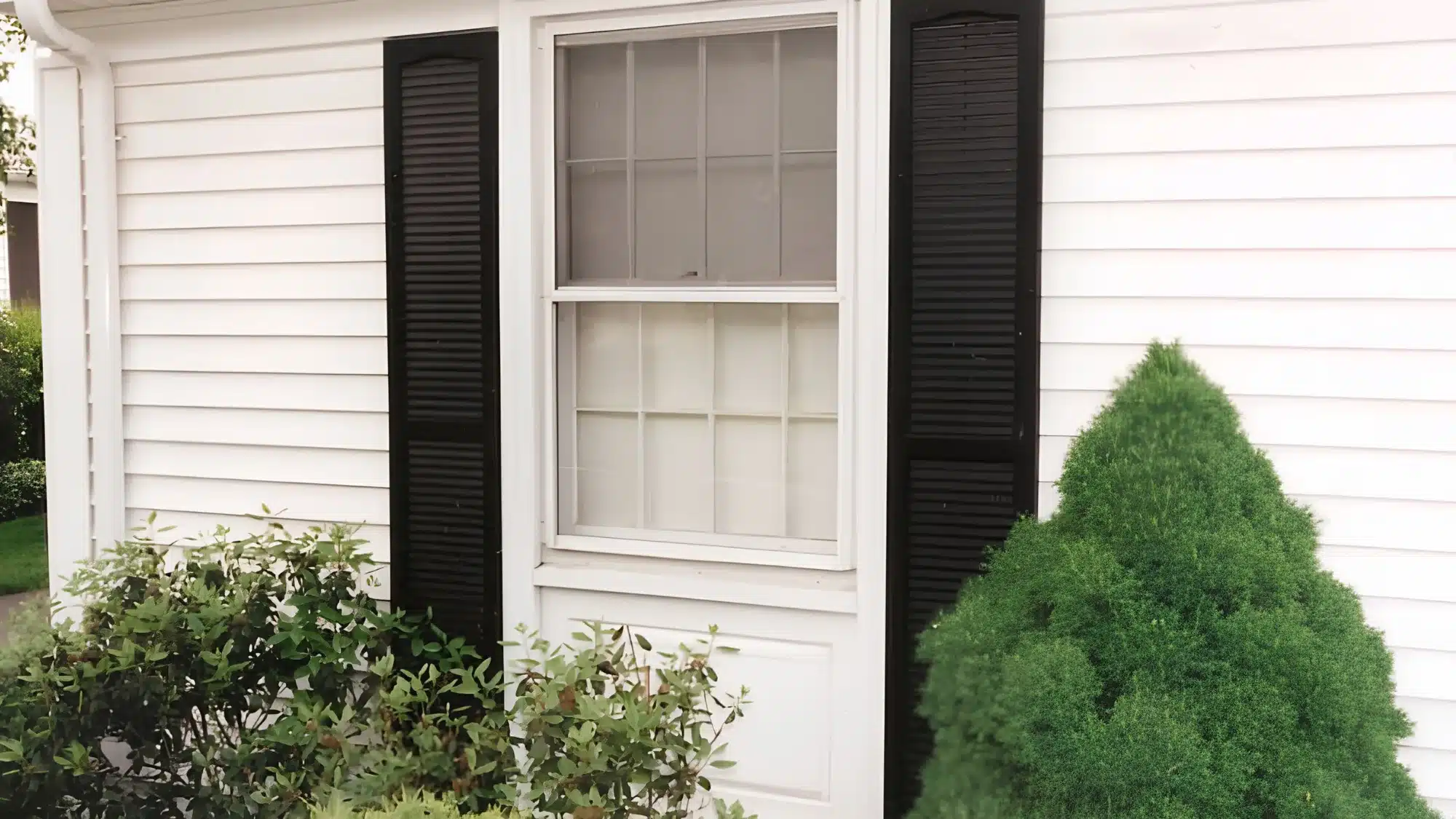 essential-questions-to-ask-a-window-contractor-before-hiring-them-for-your-home A homeowner discusses window replacement options with a professional contractor inside their living room.