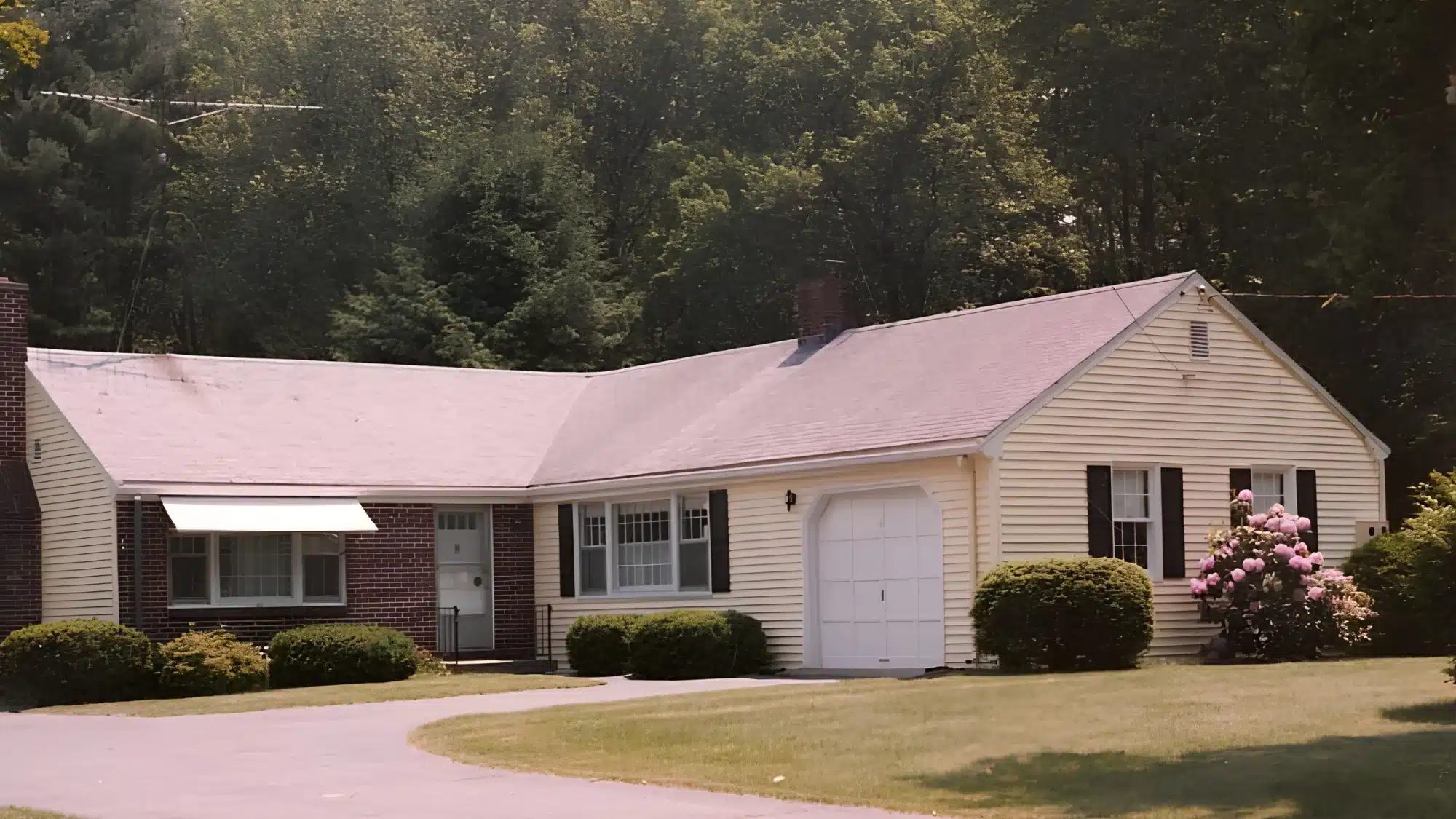 protect-your-home-by-choosing-a-qualified-roofing-contractor-in-windsor-ct A professional roofing contractor inspects a sturdy, well-maintained roof on a family home.