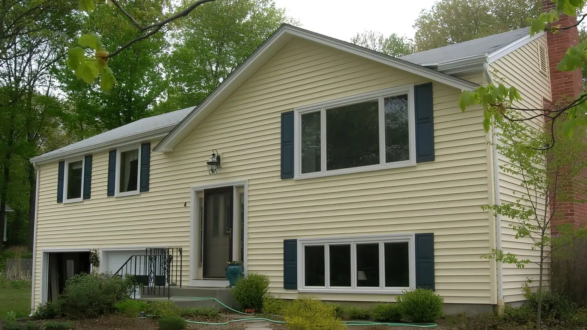 the-essential-guide-to-understanding-the-services-vinyl-siding-contractors-in-east-granby-provide An expert contractor meticulously installs new vinyl siding on a beautiful home in East Granby.